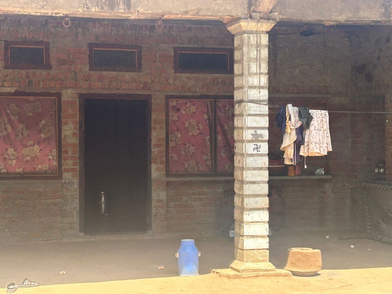 Brick home with a shaded veranda and household items