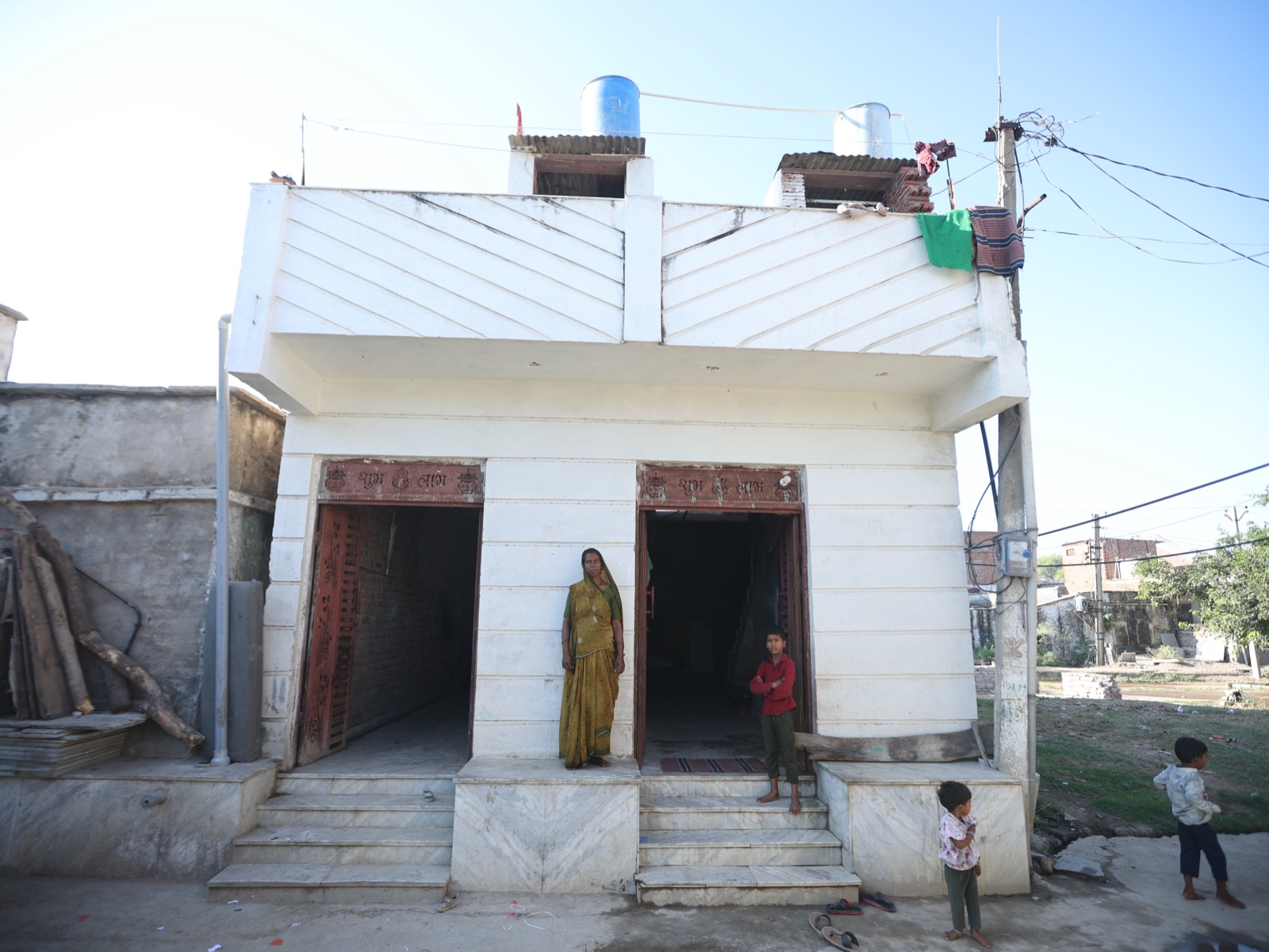 A woman and children outside a newly built two-room house